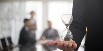 Businessman holding an hour glass, signifies the importance of being on time